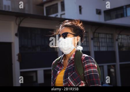 Woman walking in the street and wearing a Corona Virus face mask Stock Photo