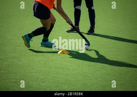 Female hockey player exercising on the field Stock Photo