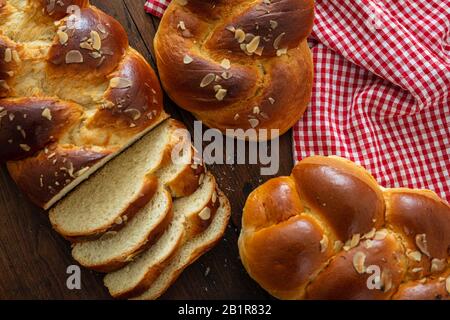 Sweet breads, easter tsoureki cozonac sliced on wood table background, top view. Braided brioche, festive traditional challah Stock Photo