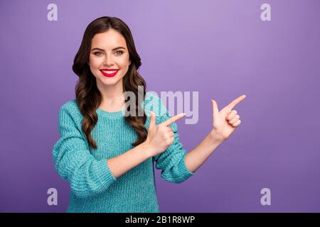 Photo of pretty attractive lady presenting advising low shopping discount prices direct fingers side empty space nice offer wear blue pullover Stock Photo