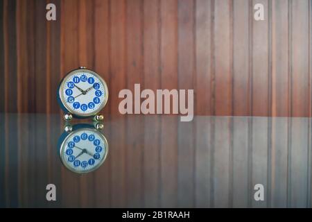 Small vintage blue table clock with reflection. Stock Photo