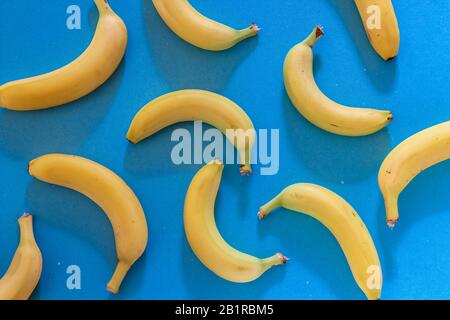Colorful pattern with fresh bananas on blue background. Wallpaper Stock Photo