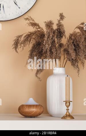 Natural interior decor. Still life composition with reeds, bee wax candle and essential oil diffuser Stock Photo