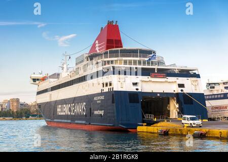 Piraeus, Greece - May 7, 2018: Large car-ferry docked in seaport near Athens. Big ship in a sea harbor. Ferryboat loading or unloading by a port pier. Stock Photo