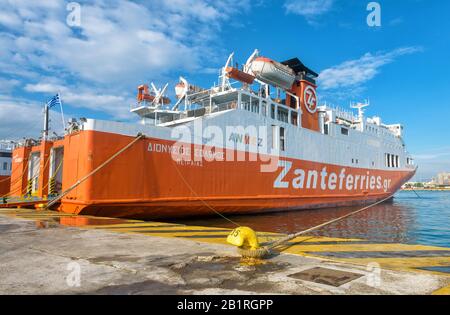Piraeus, Greece - May 7, 2018: Large car-ferry docked in seaport near Athens. Big ship in a sea harbor. Ferryboat loading by a port pier. Concept of t Stock Photo