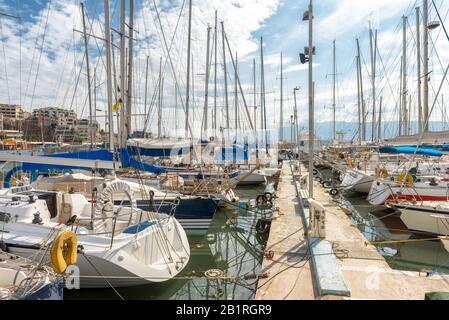 Yachts docked in sea port in Piraeus, Athens, Greece. Modern sailing boats mooring in beautiful marina in summer. Scenic view of nice yachts in harbor Stock Photo