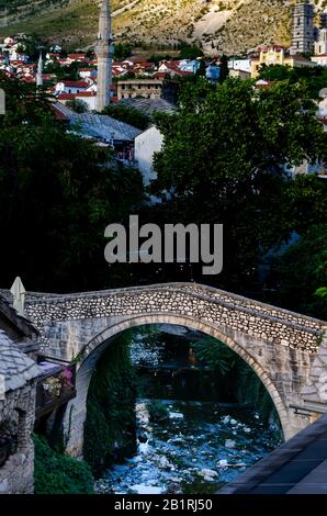 Another ancient bridge in Mostar: the Kriva Cuprija (the Crooked Bridge). It crosses the Rabobolja creek, a right-bank affluent of the Neretva river. Stock Photo