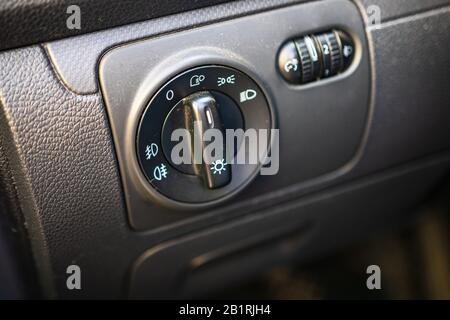 The dashboard of dusty car's interior is black with a dipped headlamp switch and side lights with a light sensor and automatic dimming and fog light b Stock Photo