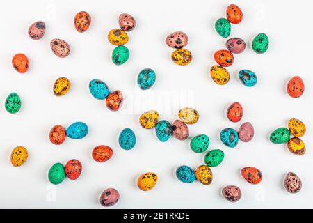 Stylish background with colorful quail, easter eggs with copy space for text isolated on white background. Flat lay, top view, mockup, overhead Stock Photo