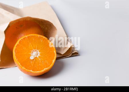 Storage of fresh orange in paper bag. Correct storage. Zero waste. Plastic free. Space for text. Stock Photo