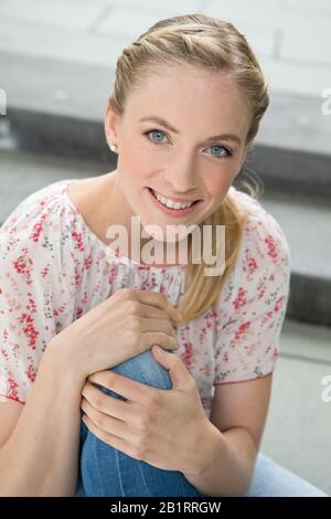 Young woman sitting on stairs, portrait Stock Photo