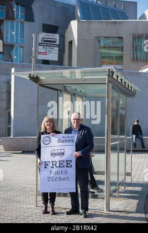 Edinburgh, UK. 27 February 2020. Pictured: (L-R) Alison Johnstone MSP; Andy Wightman MSP. Ahead of the budget debate this afternoon Scottish Greens Parliamentary Co-Leaders Alison Johnstone MSP and Patrick Harvie MSP along with the Green MSP group will stage a photocall outside the Scottish Parliament to celebrate their free bus travel for under 19s budget win. The Scottish Greens yesterday announced that a deal had been struck on free bus travel, more money for councils, extra resource for community safety and an additional £45 million package to tackle fuel poverty and the climate emerge Stock Photo