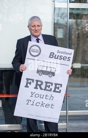 Edinburgh, UK. 27 February 2020. Pictured: John Finnie MSP - Justice, Transport & Tourism, Rural & Island Communities and Scottish Green Party MSP for the Highlands and Islands. Ahead of the budget debate this afternoon Scottish Greens Parliamentary Co-Leaders Alison Johnstone MSP and Patrick Harvie MSP along with the Green MSP group will stage a photocall outside the Scottish Parliament to celebrate their free bus travel for under 19s budget win. The Scottish Greens yesterday announced that a deal had been struck on free bus travel, more money for councils, extra resource for community s Stock Photo