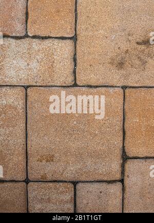 Vertical background with geometric pattern of highly detailed street pavement made of various square blocks with textured rough beige or brown surface Stock Photo