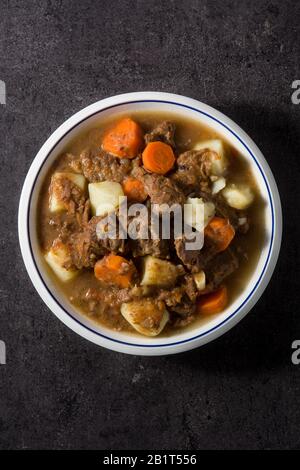 Irish beef stew with carrots and potatoes on black background Stock Photo