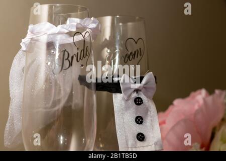 two novelty champagne flutes or champagne glasses with the words bride and groom written on them Stock Photo