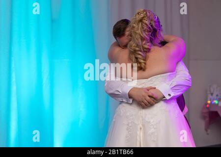 a bride and groom dancing their first dance on their wedding day at their wedding reception Stock Photo