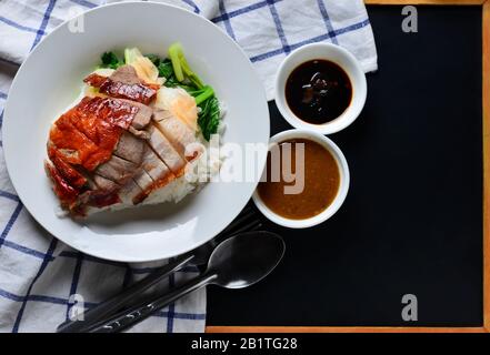 Rice with roasted duck and crispy skin pork belly Stock Photo