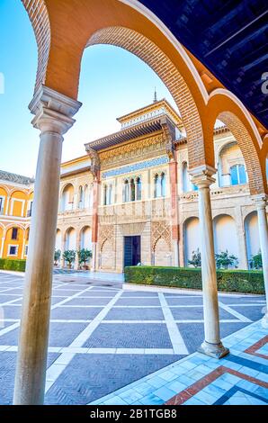 SEVILLE, SPAIN - OCTOBER 1, 2019: The view through arcade on beautiful facade of Pedro I Palace in Royal Alcazar, on October 1 in Seville Stock Photo