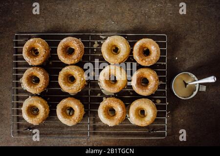Hot Frosted Doughnuts on a Cooling Rack with a Perspective from Above Stock Photo