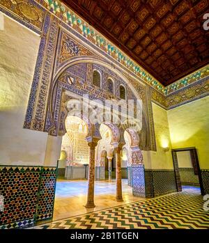 SEVILLE, SPAIN - OCTOBER 1, 2019: The beautiful horseshoe arches with carved patterns leading to the Ambassadors Hall of King Pedro Palace in Alcazar Stock Photo