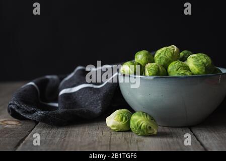 Bowl of Brussels sprouts and napkin on a rustic wooden table. Stock Photo