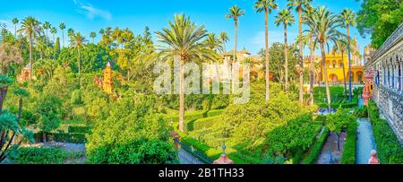 SEVILLE, SPAIN - OCTOBER 1, 2019: The pleasant walk in arched Grotesque Gallery with a view on amazing Gardens of Alcazar complex, on October 1 in Sev Stock Photo