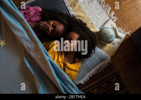 Overhead view of sisters relaxing at home Stock Photo