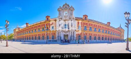 SEVILLE, SPAIN - OCTOBER 1, 2019: Panoramic view on large facade of Palace of San Telmo wit hscenic central stone portal, on October 1 in Seville