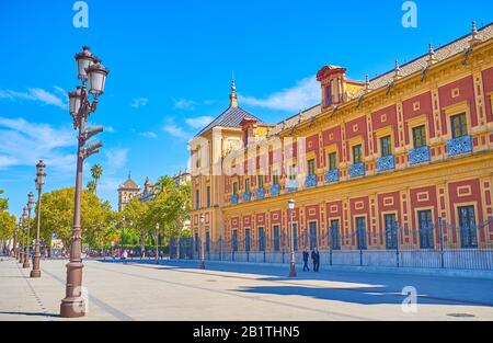 SEVILLE, SPAIN - OCTOBER 1, 2019: Walk along large Palacio de San Telmo (Palace of San Telmo) and enjoying magnificent Spanish Baroque style facade, o