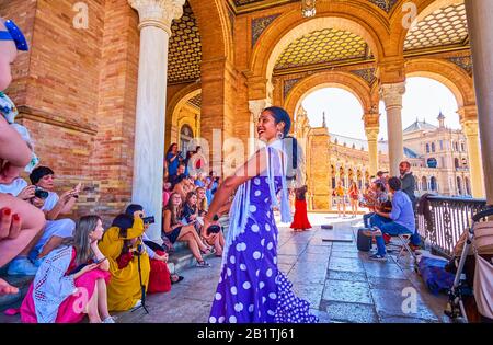 SEVILLE, SPAIN - OCTOBER 1, 2019: The street dancer amuses tourists with emotional flamenco dance in gallery of Plaza de Espana, October 1 in Seville Stock Photo