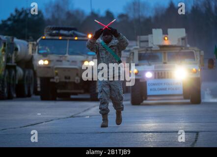Hagenow, Germany. 27th Feb, 2020. A US soldier in the Ernst Moritz Arndt barracks of the German Federal Armed Forces gives the departure signal for the continuation of the major NATO exercise 'Defender Europe 2020'. After spending the night and refuelling and servicing their vehicles, the convoy will continue its journey east in the evening. More US transports are expected in the next few days, with a total of 1,700 US soldiers expected to pass through Mecklenburg-Western Pomerania by March 6. Credit: Jens Büttner/dpa-Zentralbild/dpa/Alamy Live News Stock Photo