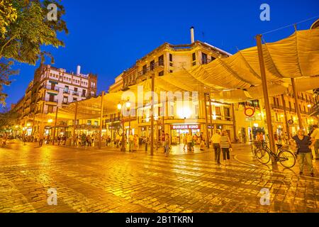 SEVILLE, SPAIN - OCTOBER 1, 2019: The bright illuminated awnings above the pedestrian sidewalk on Calle Campana, on October 1 in Seville Stock Photo