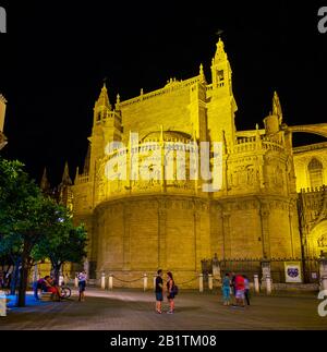 SEVILLE, SPAIN - OCTOBER 1, 2019: The pleasant evening walk in old Seville in surrounding of magnificent illuminated medieval landmarks, such as the C Stock Photo