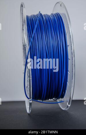 Plastic for 3D printing. Blue plastic filament, red ABS/PLA coil for 3d printer on white background, isolated Stock Photo