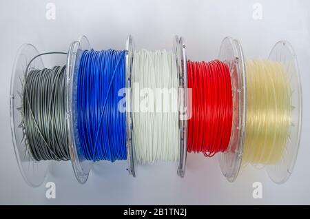 Plastic for 3D printing, different colors plastic filament, ABS/PLA coil for 3d printer on white background, isolated. Plastic for three-dimensional Stock Photo