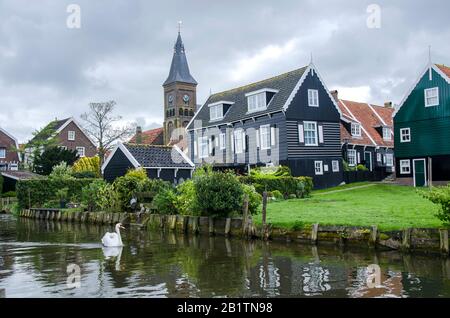 Traditional wooden fishing houses, canal and swan, Marken, Netherlands Stock Photo