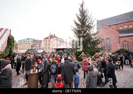 Riga, Latvia - December 08 2019. Christmas market on Dome Square, in the Old Town. People buying traditional souvenirs at a European Christmas market Stock Photo