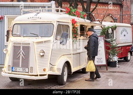 Riga, Latvia - December 08 2019. Christmas market on Dome Square, in the Old Town. People buying traditional souvenirs at a European Christmas market Stock Photo