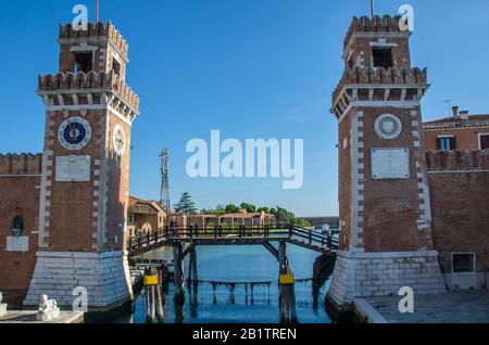 Old Arsenal ornamental towers in Venice during sunny day, Italy. View of Rio de l'Arsenale and houses along a canal - the historic main water entrance Stock Photo