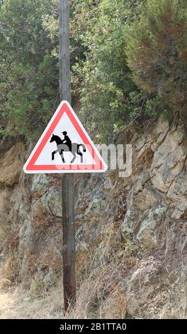 road sign with the symbol attention to the crossing of horses near a riding center Stock Photo