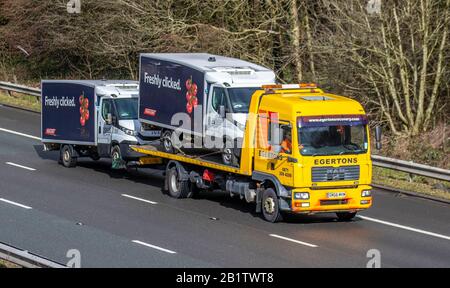 2007 yellow Egertons Haulage delivery trucks, lorry trailer, transportation, Tesco van breakdown recovery, vehicle carrier, 2017 Man Tg-M vehicle, European commercial transport, trucking industry, M61 at Manchester, UK Stock Photo