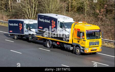 2007 yellow Egertons Haulage delivery trucks, lorry trailer, transportation, Tesco van breakdown recovery vehicle carrier, 2017 Man Tg-M vehicle, European commercial transport, trucking industry, M61 at Manchester, UK Stock Photo