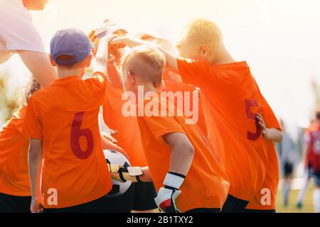 Happy Kids Sports Team Stacking Hands At The Field. Children Team ...