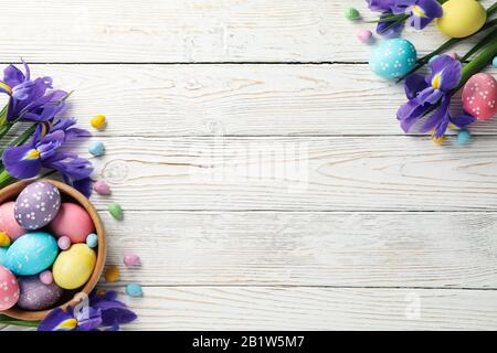 Composition with Easter eggs and Iris flowers on wooden background, space for text Stock Photo