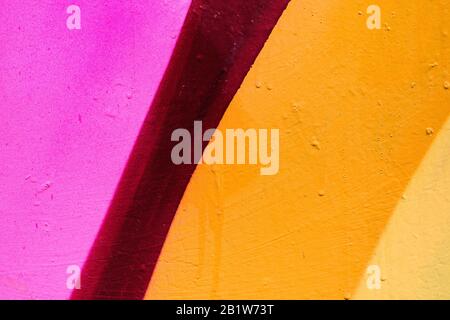 Abstract metal texture with a brush painted in pink, yellow, orange and brown line. Close up. Stock Photo