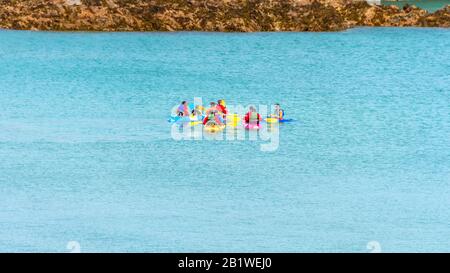 Canoeing on the sea in Guernsey . A group of people                                 in colourful canoes. Stock Photo