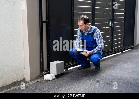 Repairman Fixing Broken Automatic Door In Building Stock Photo