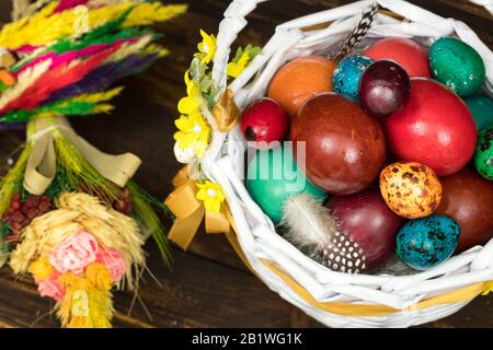 Happy Easter. Traditionally, colorfully painted eggs in a basket. Background of old boards, festive decor Stock Photo