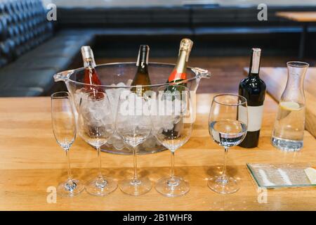 Empty glasses, bottle of assorted wine in a bowl with ice Stock Photo